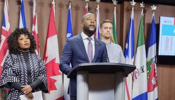 Black Class Action Secretariat's Nicholas Marcus Thompson, centre, and Bernadeth Betchi, left, are suing the Government of Canada for alleged systemic anti-Black discrimination within the federal public service. Pictured right is Canadian Association of Professional Employees’ Nathan Prier. The Hill Times photograph by Mike Lapointe