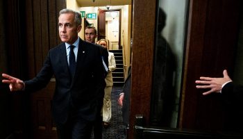 Prime Minister Mark Carney enters the House of Commons foyer before Question Period on  Oct. 9, 2025. (Guy behind Carney is Jeff Costen) The Hill Times photograph by Andrew Meade