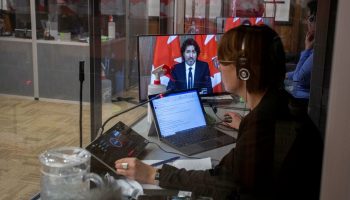 Interpreters are pictured at work in sound booths during a press conference with Prime Minister Justin Trudeau in the Sir John A. Macdonald Building in February 2021.  Andrew Meade