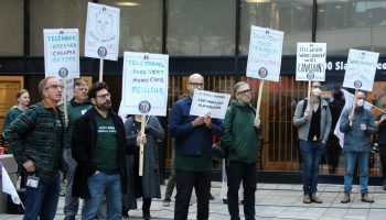 Protesters at a Sept. 9 rally against the new in-office mandate for public servants hold signs saying remote work is ‘greener, cheaper, better.’